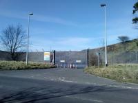 The coal discharge shed here, south of the power station, was rather prominent on its embankment until it was demolished in 2017 a couple of years after the power station itself. The branch continued climbing sharply to the buffers (to the right). That spot would make a commanding viewpoint - if the whole embankment weren't fenced off. The yellow sign reads 'Power Station Coal Plant'.<br><br>[David Panton 29/03/2018]