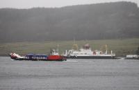 <I>MV Red Baroness</I>, a versatile landing-craft design operated by Troon Tug Co Ltd (a sort of modern day <I>Clyde Puffer</I>), makes its way through the Kyles of Bute with a cargo of fish farm supplies on a dreich 3rd April 2018. In the background <I>MV Loch Dunvegan</I> is at Rhubodach about to return to Colintraive.<br><br>[Mark Bartlett 03/04/2018]
