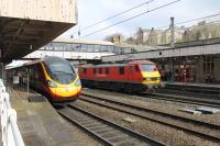 Virgin 390127 just squeezes onto Platform 3 at Lancaster in time to reveal DB 90040 southbound on the Up Fast line heading for Daventry on 13th March 2018. EWS liveried 90028 was working in multiple on this intermodal service but out of sight behind the Pendolino. <br><br>[Mark Bartlett 13/03/2018]