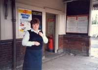 Neilston (High). Back when stations had staff. The entire staff standing next to the now demolished station building. Note adverts for Prestwick Airport and InterCity sleepers.<br><br>[Ewan Crawford //1987]