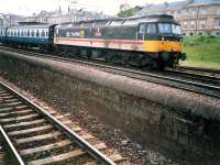 Passing Muirhouse Central Junction is a 47 hauled Carlisle-Kilmarnock-Glasgow train. Cathcart circle line in foreground.<br><br>[Ewan Crawford //1987]