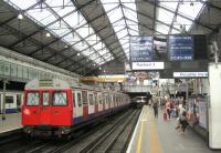 <h4><a href='/locations/E/Earls_Court_Metro'>Earl's Court [Metro]</a></h4><p><small><a href='/companies/M/Metropolitan_District_Railway'>Metropolitan District Railway</a></small></p><p>Now withdrawn LU C stock on a District Line service from Wimbledon to Edgware Road heading away from the camera as it departs from Earl's Court, on 9th August 2013. This station opened in 1878, replacing an earlier station of 1871, and since 1940 has been served exclusively by District Line trains but until then it was also served by LMS electric trains to and from Willesden Junction. Below are the deep-level Piccadilly Line platforms, opened in 1906.   Note the arrow train indicator blind, once seen at stations all over the District Line system but now only seen here. 10/14</p><p>09/08/2013<br><small><a href='/contributors/David_Bosher'>David Bosher</a></small></p>