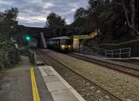 <h4><a href='/locations/A/Avoncliff'>Avoncliff</a></h4><p><small><a href='/companies/B/Bradford_line_Frome,_Yeovil_and_Weymouth_Railway'>Bradford line (Frome, Yeovil and Weymouth Railway)</a></small></p><p>Theres something rather Hollywood about the lighted steps down to the platform at Avoncliff. The train approaching is heading for Weymouth. Notice the large buttresses for the canal aqueduct. 116/122</p><p>26/09/2020<br><small><a href='/contributors/Ken_Strachan'>Ken Strachan</a></small></p>