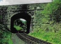 <h4><a href='/locations/B/Balerno_Goods_Junction'>Balerno Goods Junction</a></h4><p><small><a href='/companies/B/Balerno_Branch_Caledonian_Railway'>Balerno Branch (Caledonian Railway)</a></small></p><p>This bridge carried Lanark Road over the railway west of Balerno Goods Junction. This section joined the main line a mile on. The former passenger station was just ahead in this view, round the curve. 9/81</p><p>//<br><small><a href='/contributors/Don_Shaw'>Don Shaw</a></small></p>