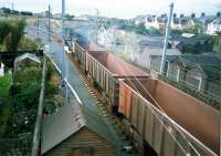 Ravenscraig-Hunterston Iron Ore empties thunder past Holm Junction. To the left is the line to Ardrossan Harbour, straight ahead was the shed and to the right is the Largs route (single for passengers, double for freight).<br><br>[Ewan Crawford //1987]