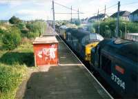 Heading for Holytown Junction are a 26 and two 37s with a long iron ore train. Holytown station had a bay platform on the left.<br><br>[Ewan Crawford //1987]