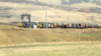 A 20 and brakevan sit in the loop at Abington and are passed by a pair of 37s and a long oil train.<br><br>[Ewan Crawford //1988]