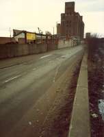 Looking west along Castlebank Street/South Street. The tarmac laid across the road where the line entered the Meadowside Granary to left. The line to Dumbarton is to the right. This was Partick West, obliterated before line closed. Area now redeveloped.<br><br>[Ewan Crawford //1988]