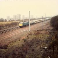 Express passing Shieldmuir Yard which served the Inshaw Works, Wishaw Steelworks, a large coal depot and provided a back route to Ravenscraig, Lanarkshire and Dalzell steelworks. Site now Shieldmuir station.<br><br>[Ewan Crawford //1988]