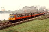 Eastbound 303 passing Bowling Harbour. Arnott Youngs yard is in the background. <br><br>[Ewan Crawford //1990]