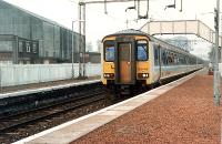 156 449 passes Bowling station with a West Highlands-Glasgow train. Arnott Youngs works to left.<br><br>[Ewan Crawford //1990]