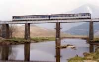Sprinter heads to Fort William over the viaduct just north of Crianlarich with a snow capped Ben More in the background.<br><br>[Ewan Crawford //1990]
