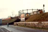 Hunterston-Ravenscraig iron ore passing a passenger train and heading east to Gilmour Street.<br><br>[Ewan Crawford //]