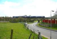 A northbound train on the southern approach section of Larbert Viaduct in April 2006 with the River Carron behind the bank to the left and Larbert station beyond.<br><br>[John Furnevel 26/04/2006]