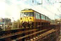 303 061 on the approach to Partick from the city. Behind is the Clydeside Expressway (which obliterated most of Partick West) and the Meadowside Granary. Taken through chain-link fence.<br><br>[Ewan Crawford //1988]