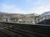 <h4><a href='/locations/B/Bangor'>Bangor</a></h4><p><small><a href='/companies/C/Chester_and_Holyhead_Railway'>Chester and Holyhead Railway</a></small></p><p>Platform for trains to Holyhead at Bangor on 6th April 2019. This is the surviving side of a former island platform, in fact both islands now only have one face in use. The old steam shed can be partly seen behind the platform canopy, still standing nearly sixty years after closure. 70/75</p><p>06/04/2019<br><small><a href='/contributors/David_Bosher'>David Bosher</a></small></p>