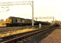 A pair of 37s take iron ore from Hunterston to Ravenscraig past Wallneuk Junction and the final remains of Greenlaw Goods - a single siding for a tamper.<br><br>[Ewan Crawford //1988]