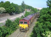 66205 leaving Leith South yard and running alongside Seafield Road with imported coal from Leith Docks to Cockenzie power station on 7 June 2006. Note the slightly projecting section of the wall to the left of the bus stop on the other side of the road, showing where one of the supports for the long demolished Caledonian bridge that crossed Seafield Road into the docks once stood. [See image 27121]<br><br>[John Furnevel 07/06/2006]