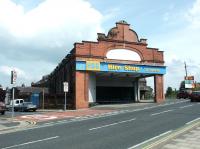 Given the EWS sign on the right and the corner of the old London Road station visible through the gap, you would be forgiven for assuming this to be an ex-railway building. Not so - Carlisle's former tram depot looking east across London Road in 2003. Officially known as the Lindisfarne Street Depot (the street on the left) it was entered by 2 x 3'6'' gauge lines opening onto 4 roads with inspection pits at the far end. Carlisle's trams ran between 1900 and 1931.  <br><br>[John Furnevel 26/05/2003]