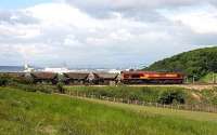 Northbound coal empties on the approach to Jamestown Viaduct in June 2006 with the Zeebrugge Ferry docking at Rosyth in the background.<br><br>[John Furnevel /06/2006]