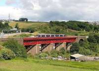 Train for Edinburgh Waverley on Jamestown Viaduct on a sunny day in June 2006. On the left is the M90 motorway and Ferry Toll Park and Ride can be seen through the viaduct. <br><br>[John Furnevel /06/2006]