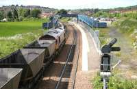 Coal empties from Longannet passing through Dunfermline Queen Margaret on their way back to Hunterston in June 2006 shortly after reversal in Halbeath sidings. The trackbed of the former S&DR route to Alloa and Stirling is on the right. [See image 46494]<br><br>[John Furnevel 13/06/2006]