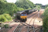 The driver of 66021 takes a final look back as his train of empties negotiates the points out of Halbeath sidings and onto the main line in June 2006 - destination Hunterston. On the adjacent line a loaded train has recently arrived and is waiting for the empties to depart before the locomotive runs round and heads for Longannet power station.<br><br>[John Furnevel 13/06/2006]